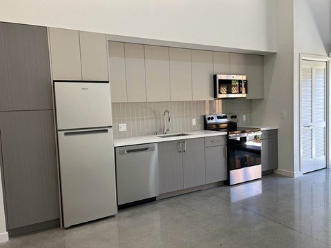 A modern kitchen with a refrigerator, dishwasher, and oven.