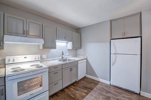 A kitchen with a white stove and a white refrigerator.