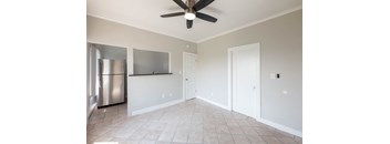 A room with a ceiling fan and tile flooring.