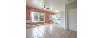 A kitchen with a red brick wall and white appliances.