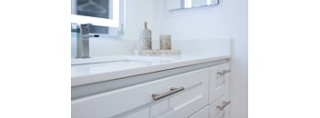A white bathroom sink with a silver faucet and a mirror above it.