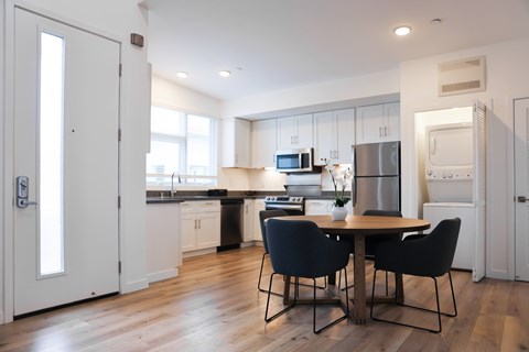 A kitchen with a table and chairs in the middle of the room.