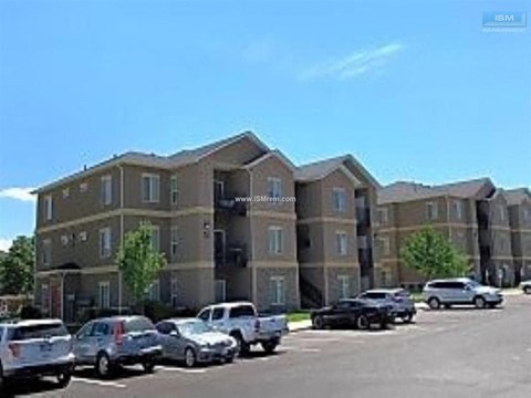 A parking lot with cars and a building in the background.