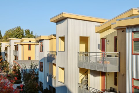 Apartment buildings with balconies and a clear blue sky.