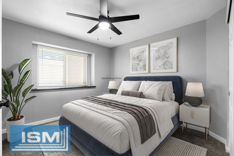 Staged bedroom with blue upholstered bed and white nightstands at Redwood Cove Apartments, Chico, California