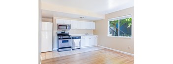 A kitchen with white appliances and cabinets.