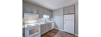A kitchen with a white stove and a white refrigerator.