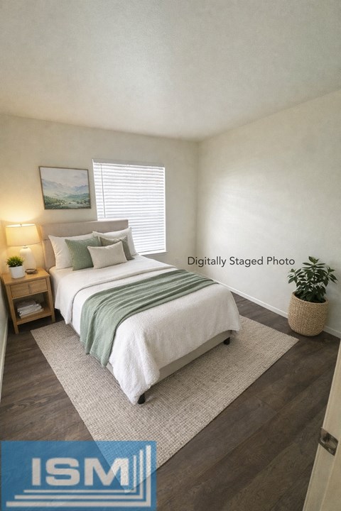 A bedroom with a bed, nightstand, and window.