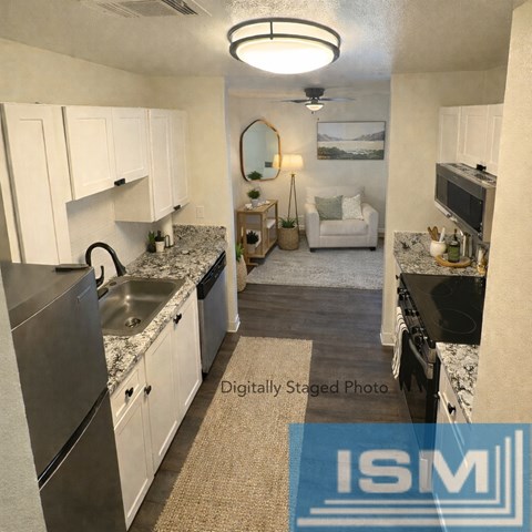 A kitchen with white cabinets and a marble countertop.