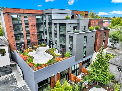 A modern multi-story building with a green roof garden.