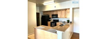 A kitchen with a black fridge, microwave, and oven.