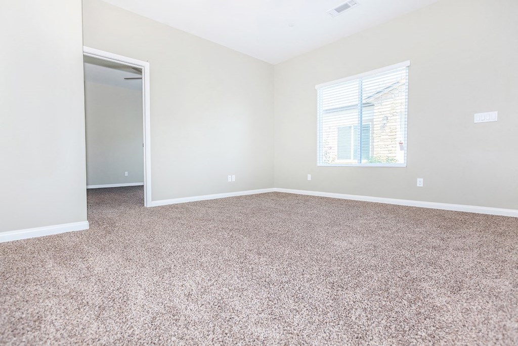 an empty room with carpet and a window