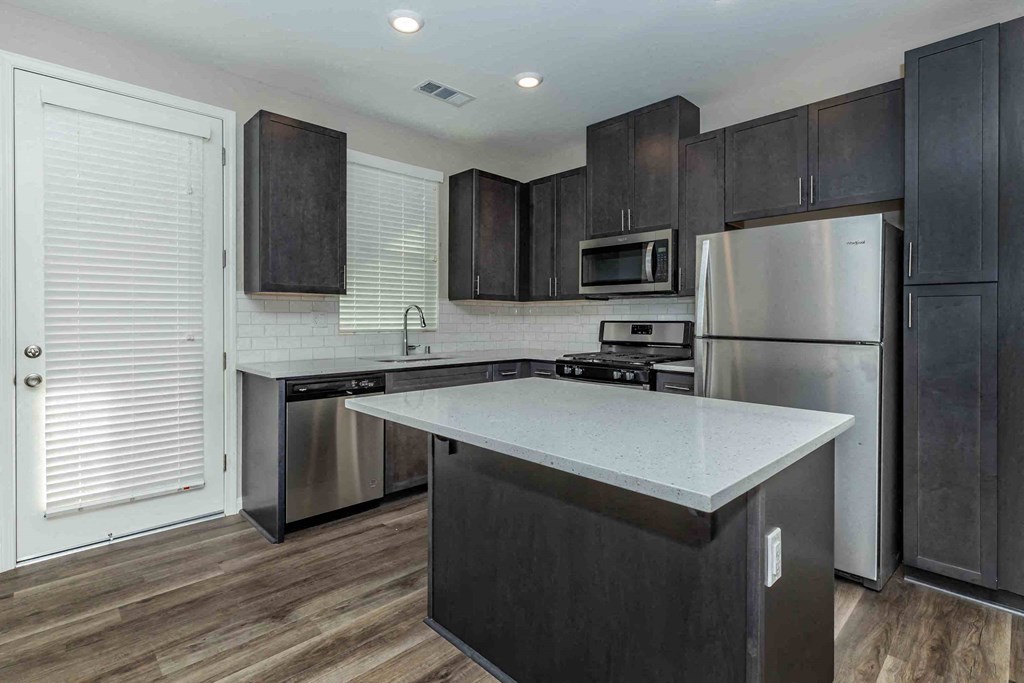 a kitchen with stainless steel appliances and black cabinets