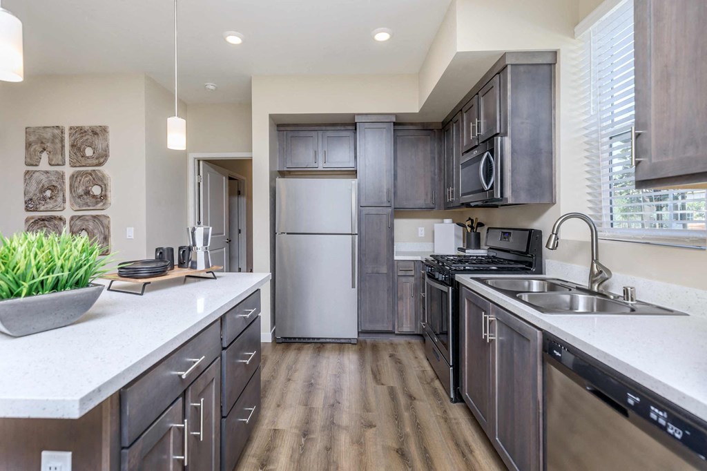 a large kitchen with stainless steel appliances and white counter tops