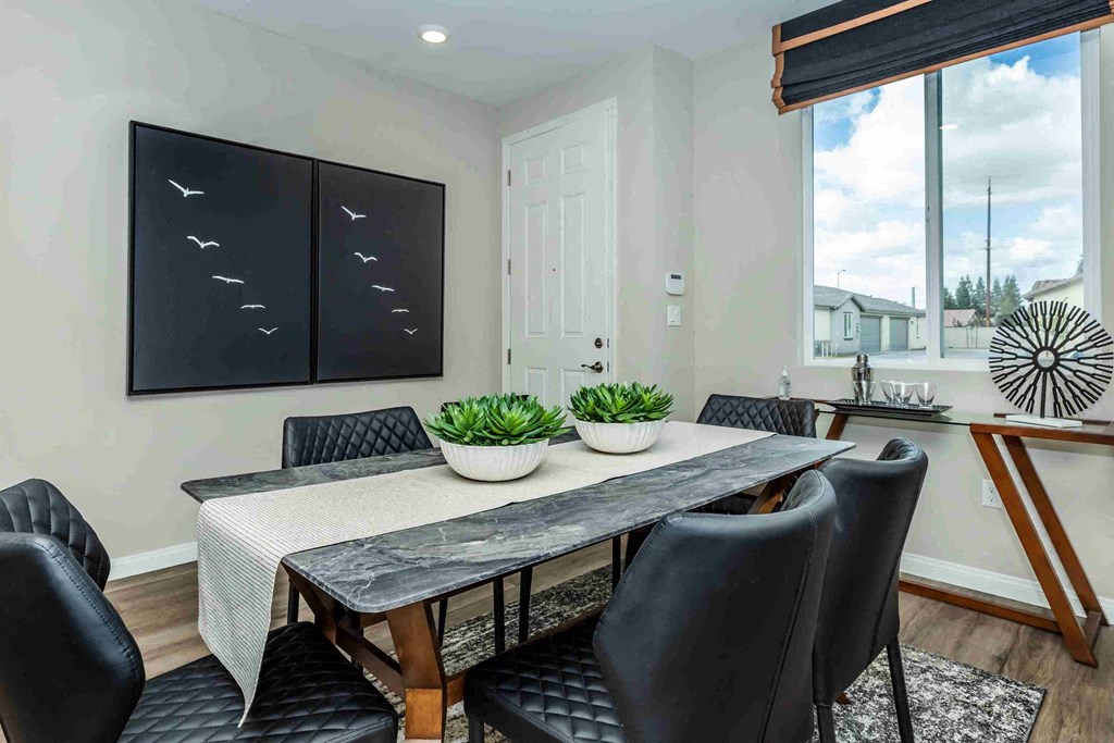 a dining room with a table and chairs and a large window