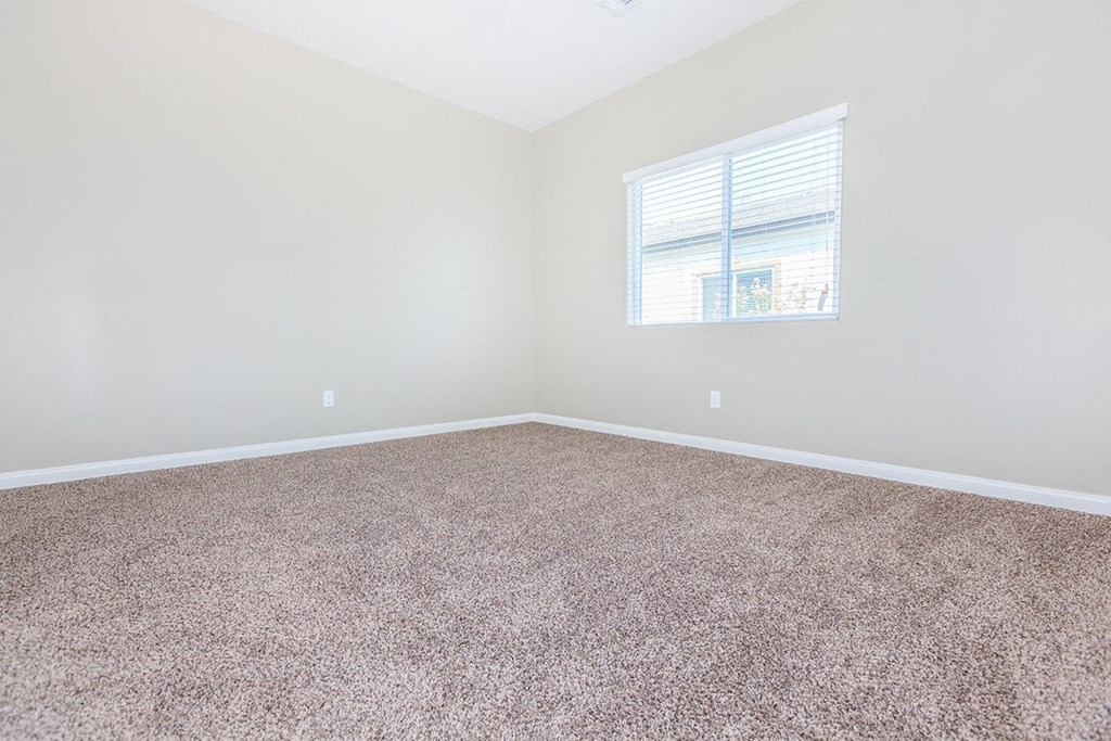an empty room with carpet and a window