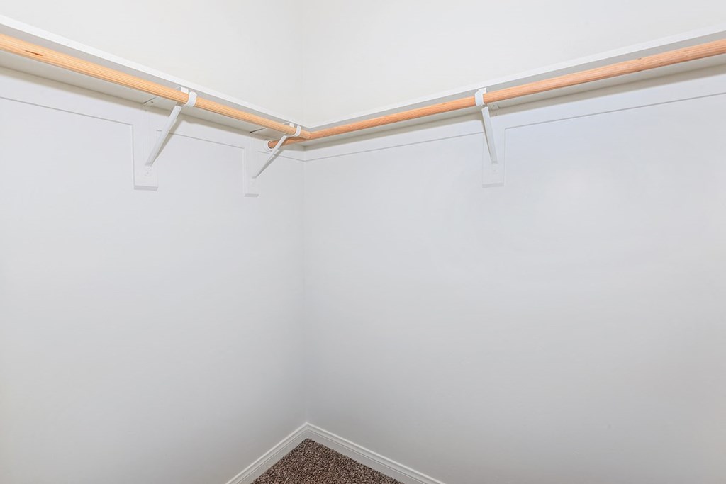 an empty room with a white wall and a pipe on the ceiling