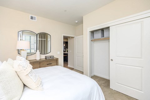 a bedroom with a white bed and a closet