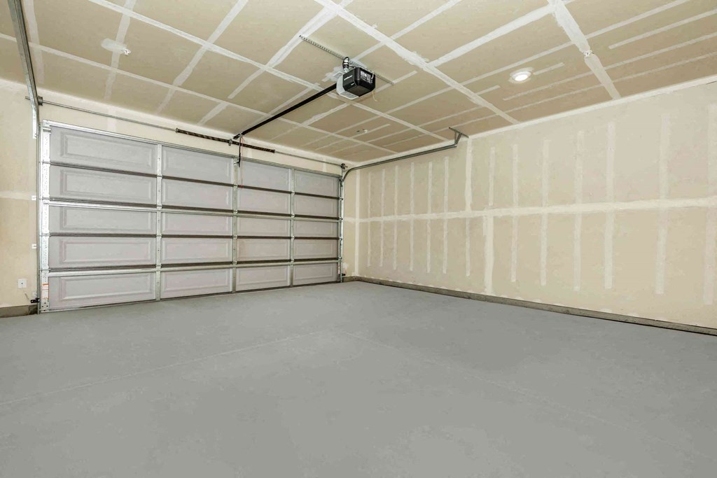 a garage with white walls and doors and a gray floor