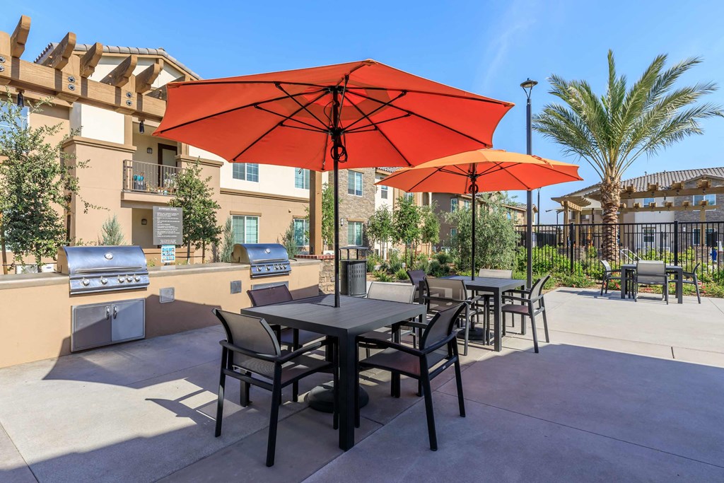 our patio has tables with umbrellas and a grill