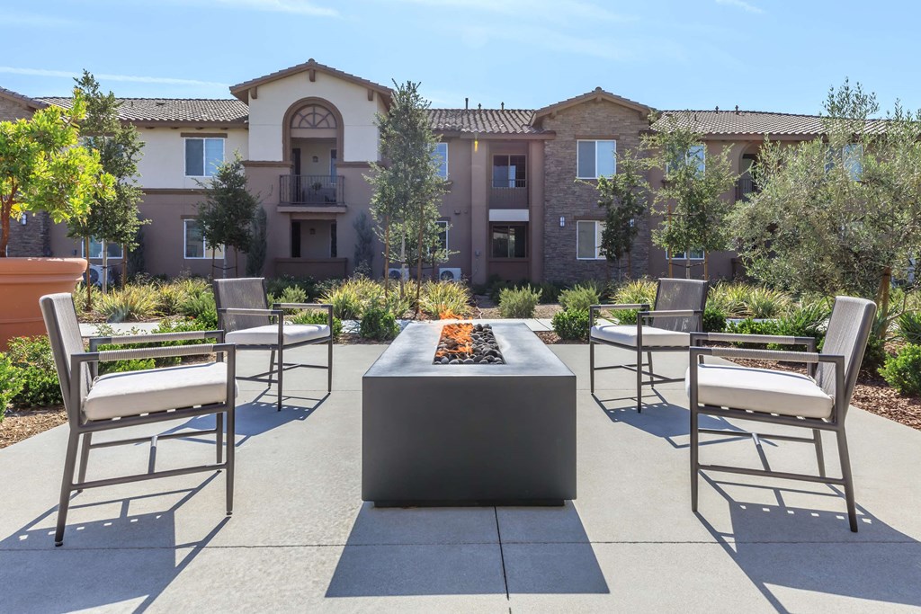an outdoor patio with chairs and a fire pit