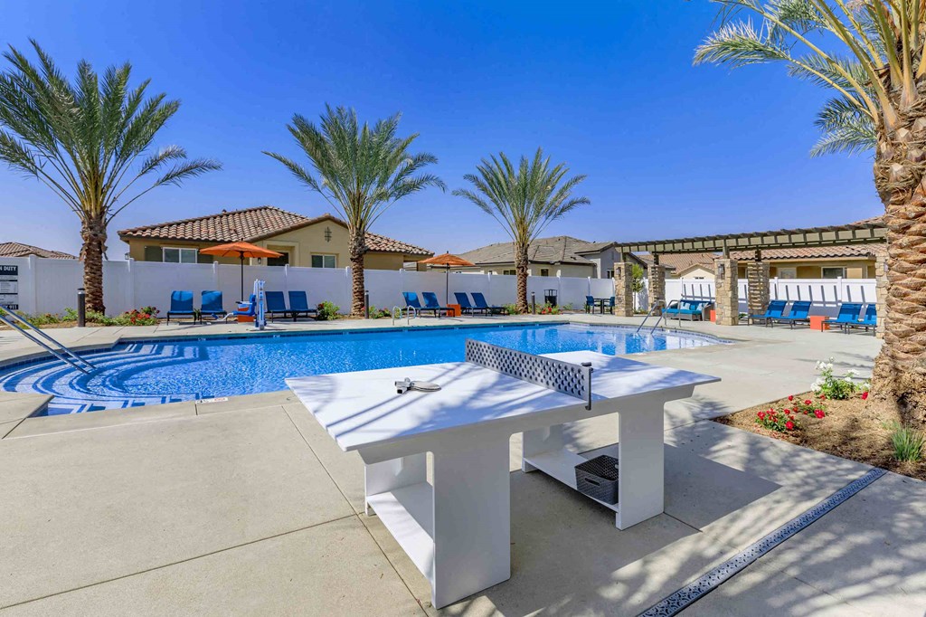 a ping pong table sits in front of a swimming pool