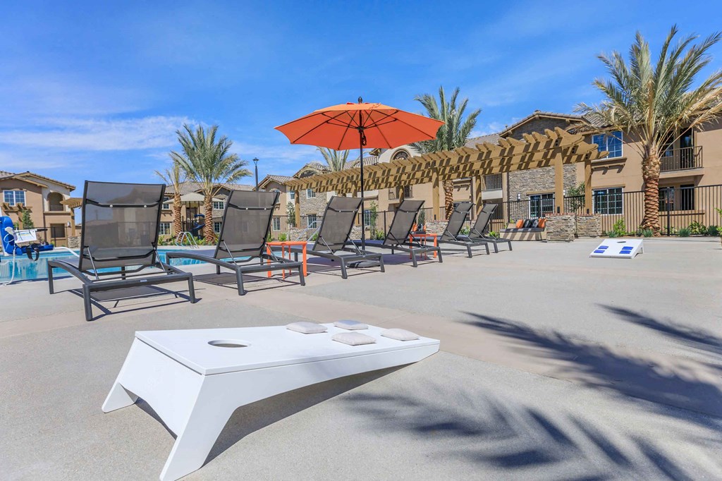 a pool with chairs and an umbrella and a table