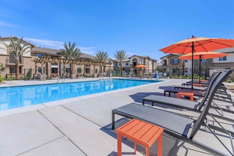 a swimming pool with chairs and umbrellas next to a resort style pool