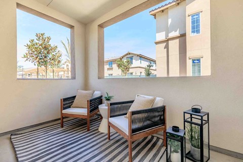 a balcony with two chairs and a striped rug