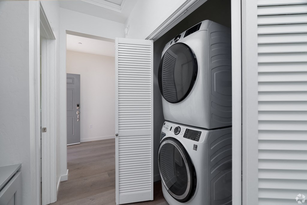 a hallway with a stacked washer and dryer