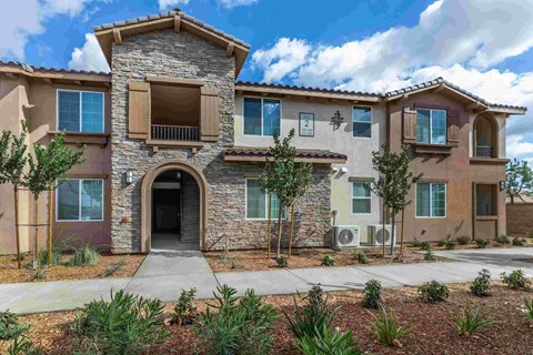 an attractive home with a stone facade and an arched doorway