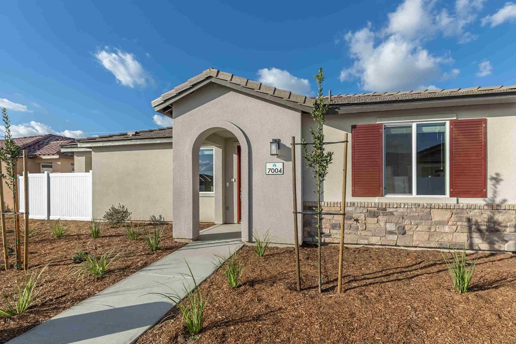 a home is shown with a sidewalk in front of it