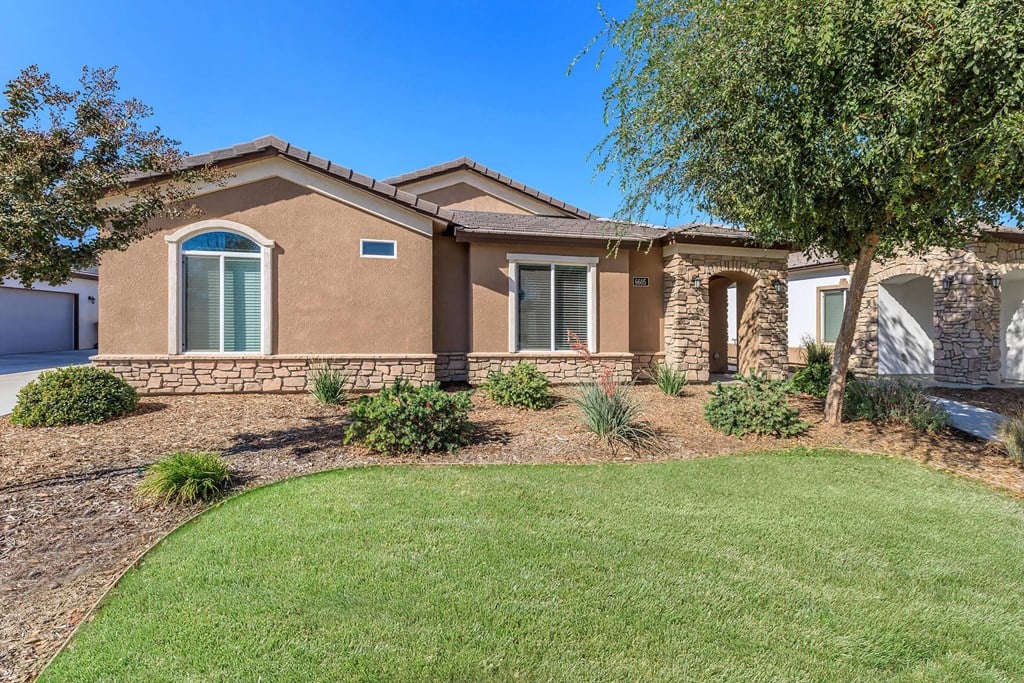 a house with a lawn and a tree in front of it