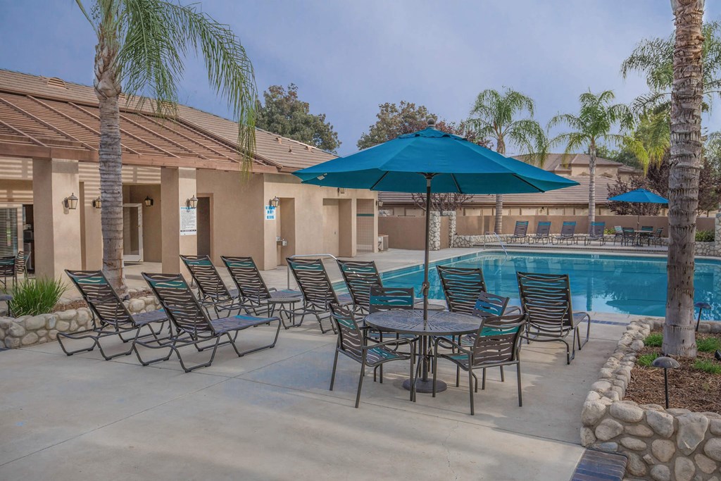 our apartments have a pool and patio with chairs and umbrellas