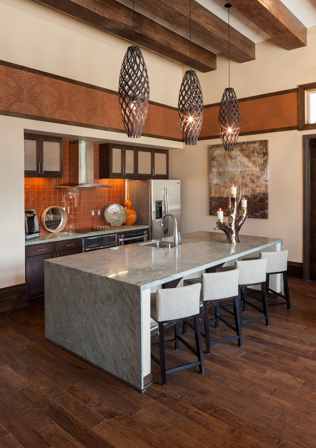 a large kitchen with a marble island with bar stool seating