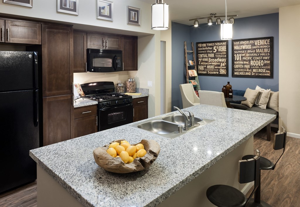 a kitchen with a granite counter top and a bowl of fruit