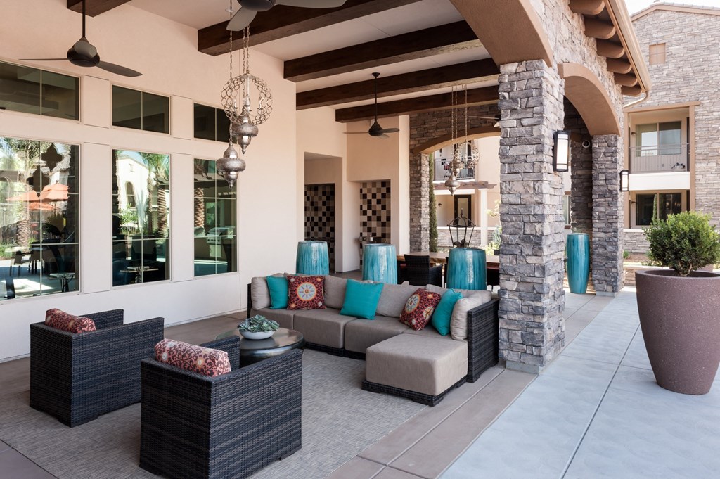 a covered patio with couches and pillows