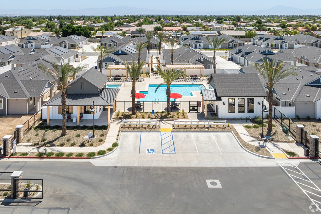 A view of a residential area with houses, a pool, and a playground.