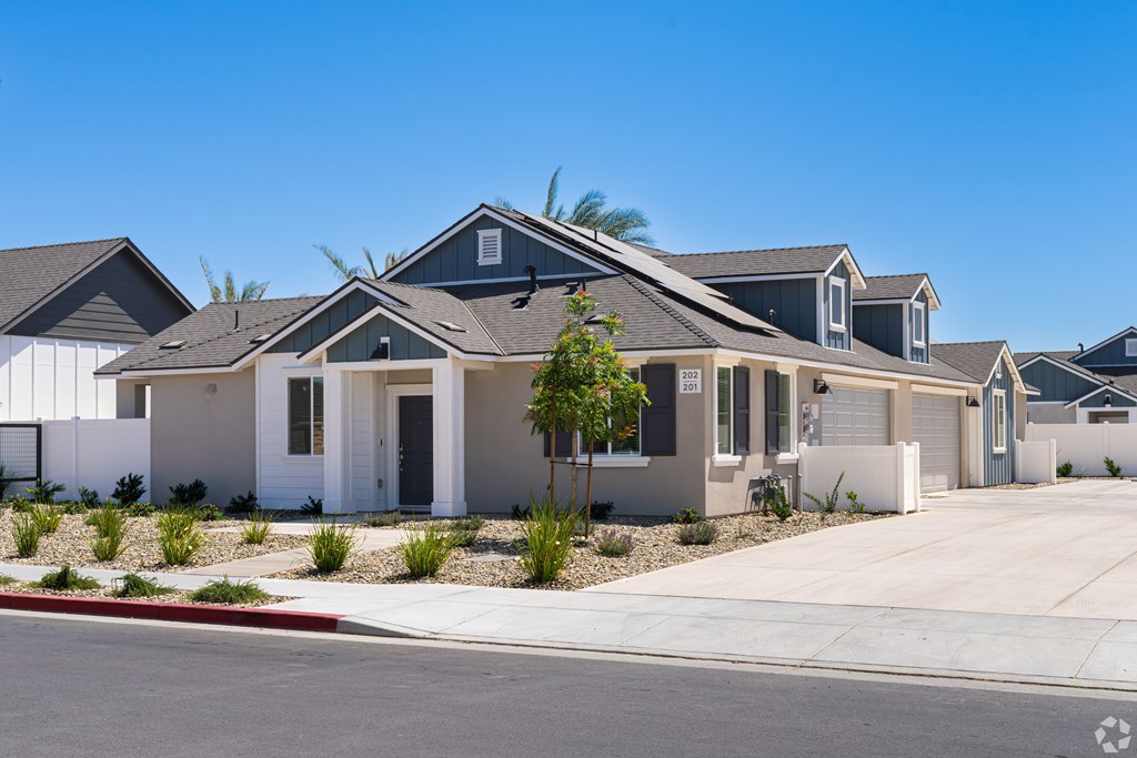 A row of houses with a clear blue sky above them.