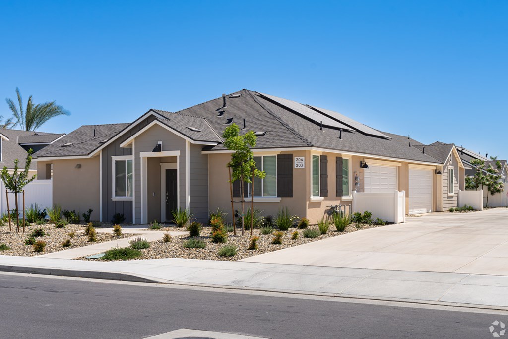A modern house with a grey roof and a white garage door.
