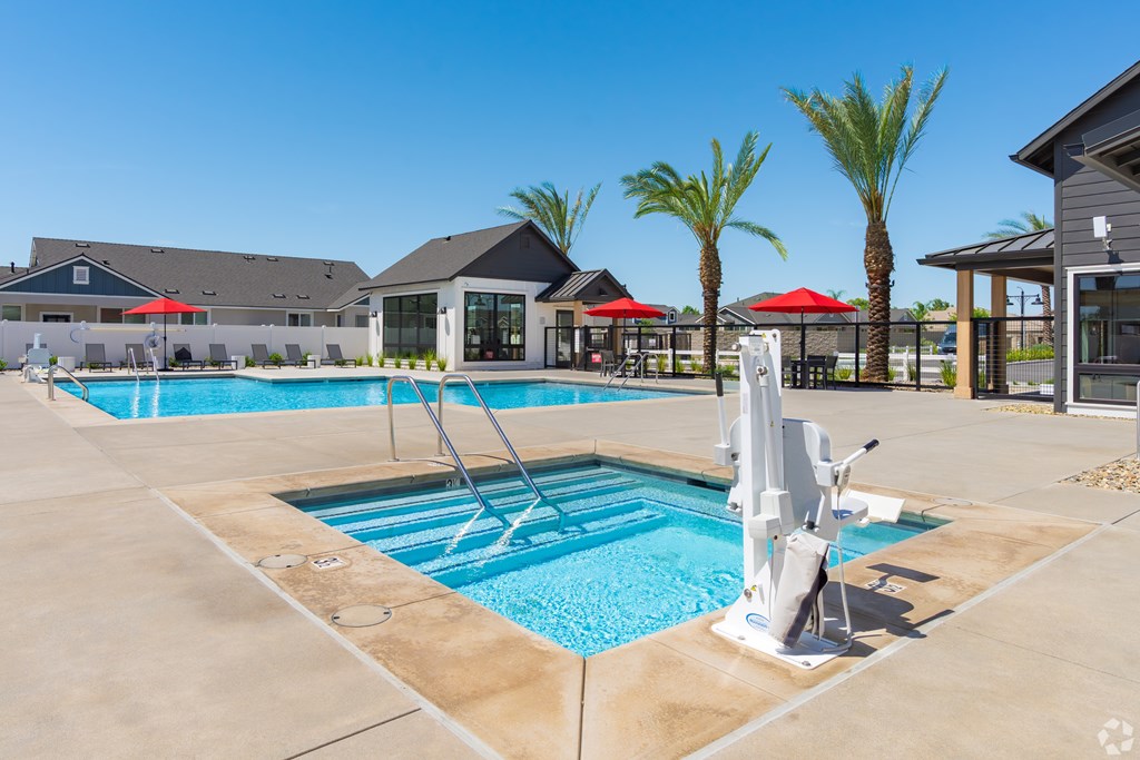 A swimming pool with a sun lounger and umbrella.