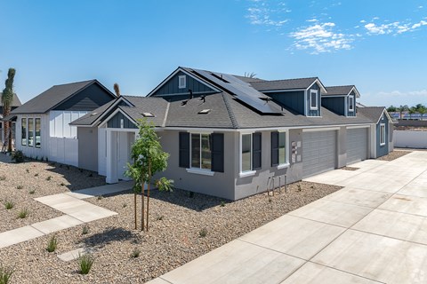 a gray house with a roof covered in solar panels