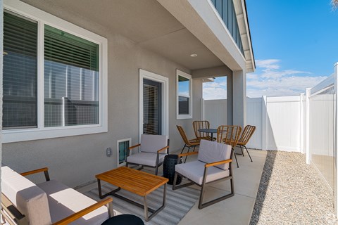 a patio with a table and chairs and a balcony