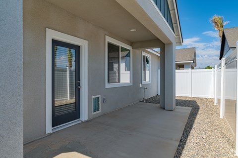 the front porch of a home with a black door and windows