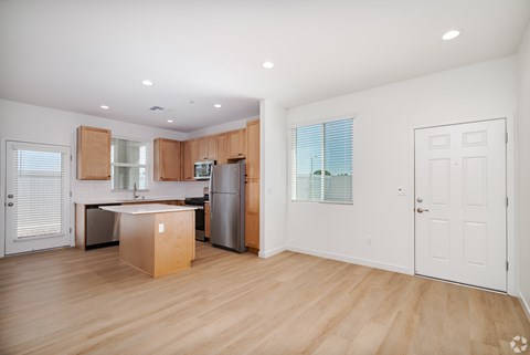 a renovated kitchen with wood flooring and a stainless steel refrigerator