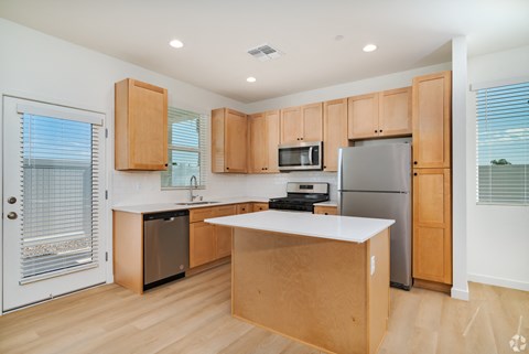 a kitchen with wooden cabinets and stainless steel appliances and a white counter top