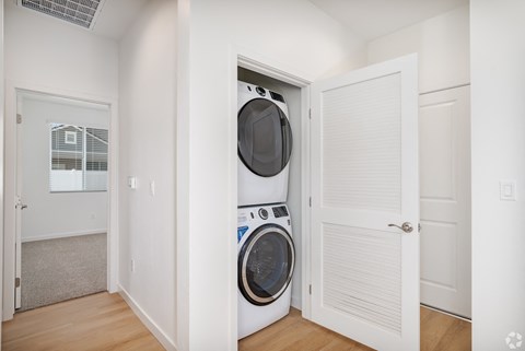 a front loading washer and dryer in a laundry room with a white door
