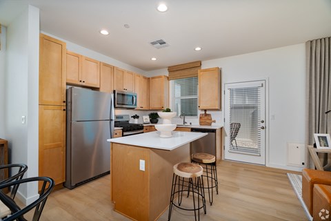 a kitchen with a center island and stainless steel appliances and wooden cabinets