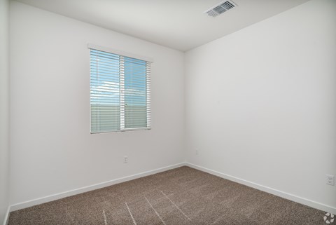 an empty room with white walls and a window