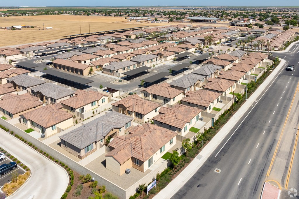 A large suburban housing development with rows of houses and a road running through it.